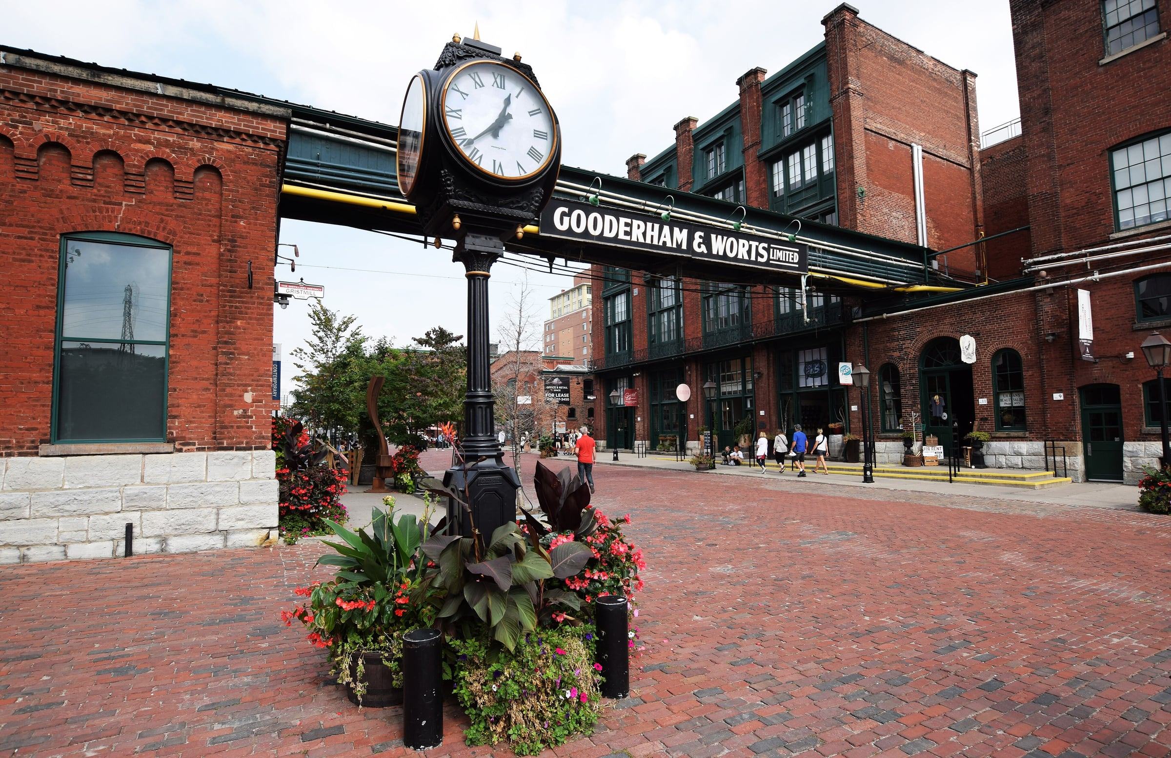 Victorian street clock and Gooderham & Worts sign over brick lanes in Toronto's Distillery District