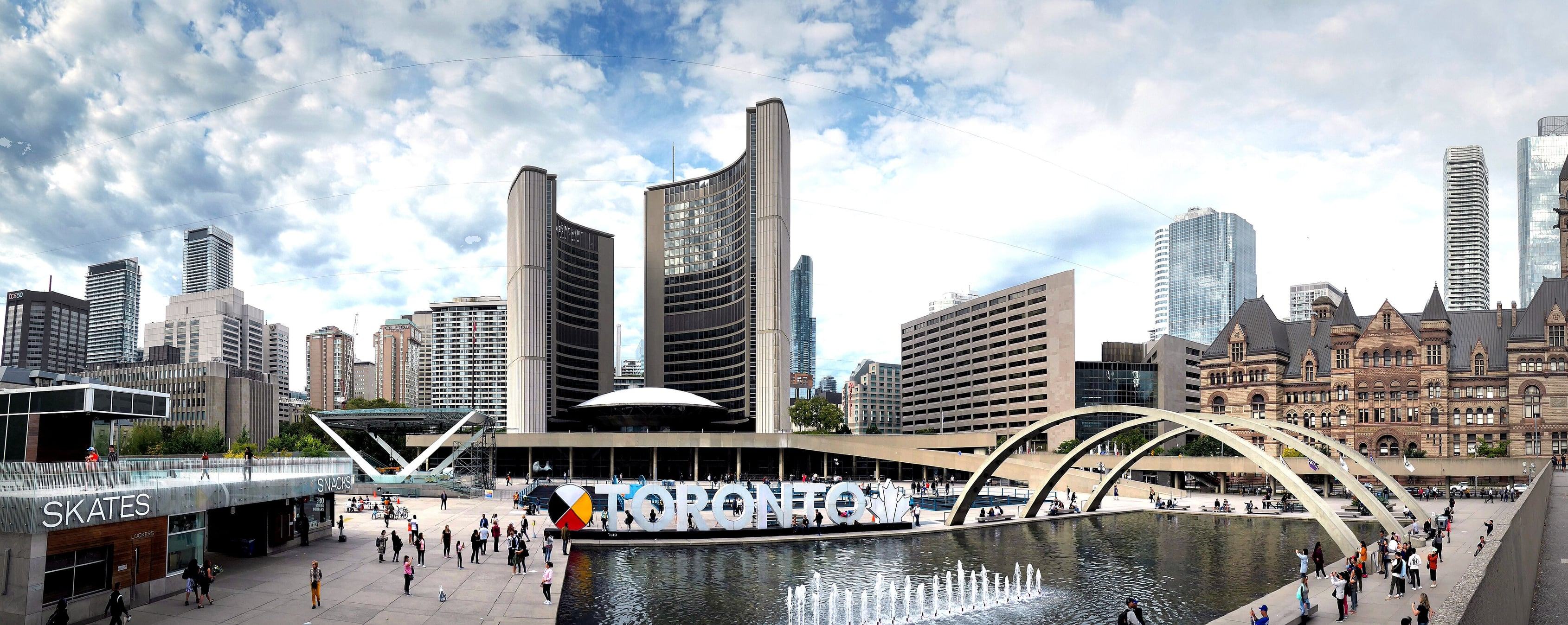 Nathan Phillips Square with the curved towers of Toronto City Hall, the Toronto sign and Old City Hall